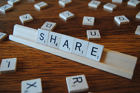 brown scrabble with S.H.A.R.E. letter display on brown wood surface thumbnail