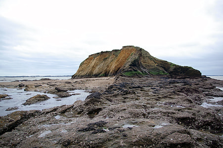 brown rock formation beside body of water thumbnail