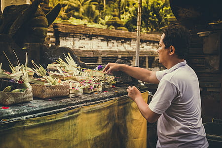 man standing in front of altar offering flower at daytime thumbnail