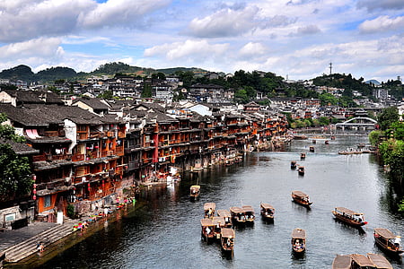 boats on body of water beside red buildings thumbnail