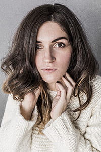 Woman in Brown Cable Knit Crew-neck Sweater Standing Near Wall thumbnail