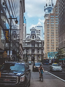 Person Riding a Bike in the Middle of the Road next to moving Cars thumbnail
