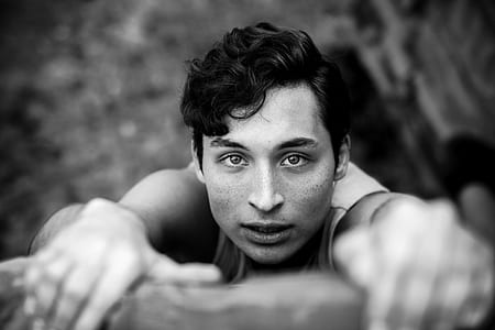 grayscale photo of man hanging on ledge thumbnail