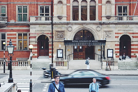 people walking outside brown building thumbnail