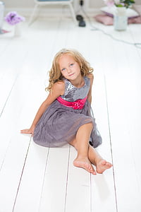 girl in gray dress sitting on white wooden floor thumbnail