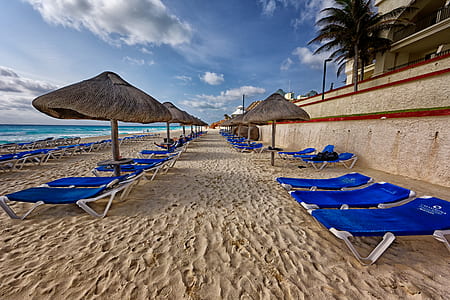 Blue and White Outdoor Chaise Lounges and Nipa Hut Beside Seashore thumbnail