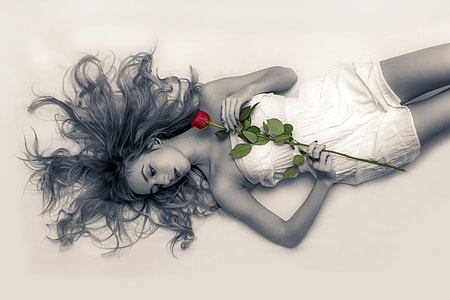 selective color photography of woman holding red rose thumbnail