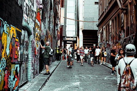 group of people on road near wall with graffiti thumbnail