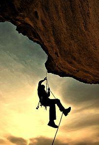 silhouette of man mountain climbing during golden hour thumbnail