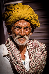 man wearing yellow turban and red and white plaid scarf thumbnail