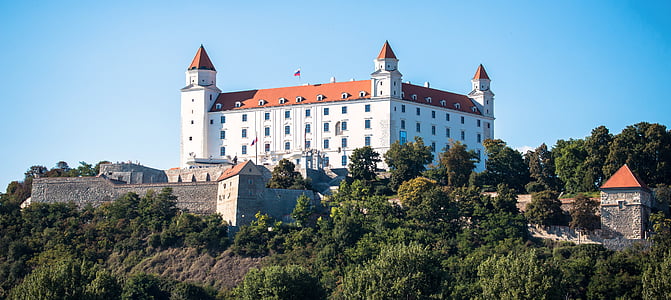 white and orange castle beside trees thumbnail