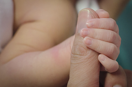 baby holding person's finger thumbnail