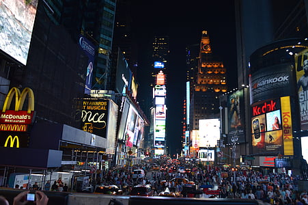 photo of people near concrete buildings at night thumbnail