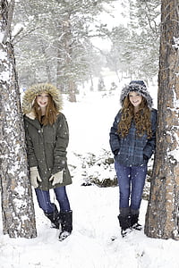 two women wearing black and blue parka jackets thumbnail