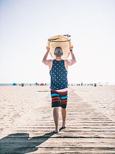 man carrying white surfboard thumbnail