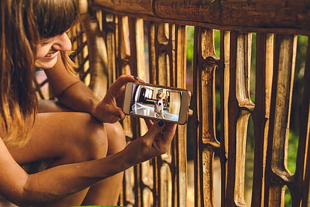 woman holding phone displaying dog on floor thumbnail