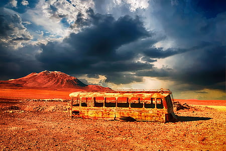 photography of brown bus frame next to brown mountain during daytime thumbnail