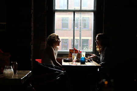 two woman deside table near window thumbnail
