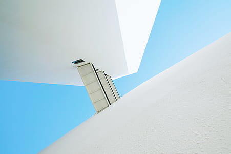 low angle photo of white concrete building under clear sky thumbnail