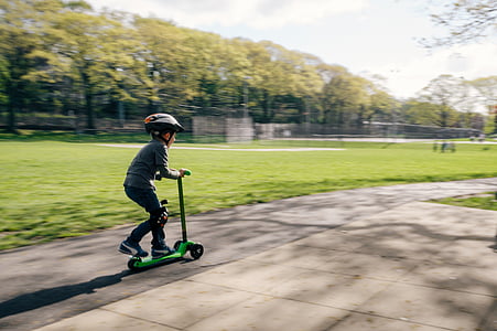 boy riding on kick scooter near trees thumbnail