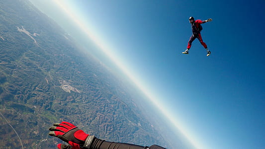 two person sky diving under blue sky thumbnail