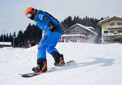 Person in Blue Coveralls Snowboarding on Snow thumbnail