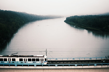 white train on railings above body of water thumbnail