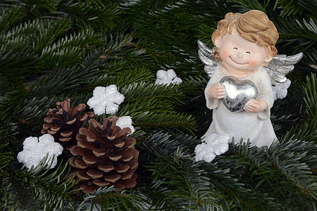 cherub holding heart near pine cone photograph thumbnail