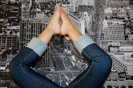 person wearing blue denim pants lying on grayscale photo of building mat thumbnail