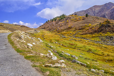 green grass beside brown mountain during daytime thumbnail