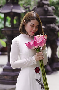 woman holding pink petaled flowers thumbnail