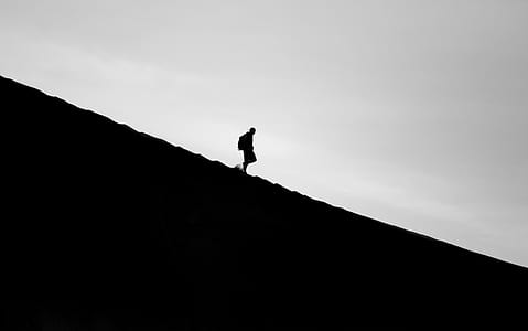 silhouette photo of person walking on slant terrain thumbnail