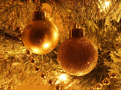 two gold baubles hanging on Christmas tree thumbnail