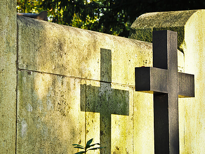 close-up photo of black wooden cross shadow on concrete wall thumbnail