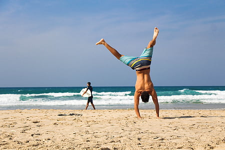 man standing using hand on seashore during daytime thumbnail