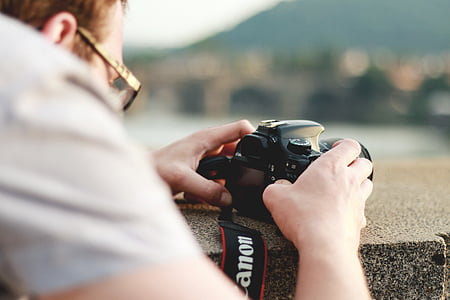 person taking a photo using black Canon DSLR camera thumbnail