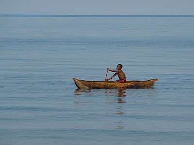 boy rowing in brown canoe thumbnail