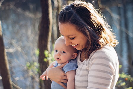 woman carrying baby during daytime thumbnail