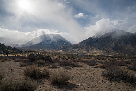 green grass field with mountain during cloudy da thumbnail