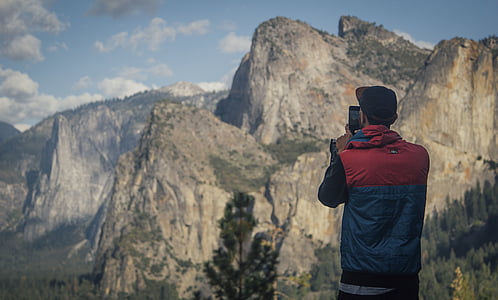 man taking photo of mountain thumbnail