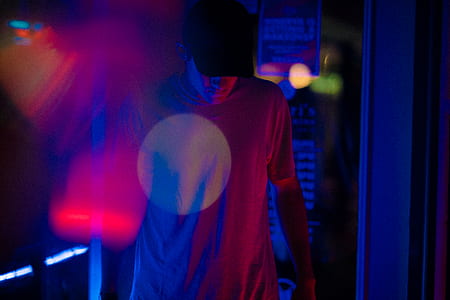 man wearing t-shirt and black cap looking down while walking thumbnail