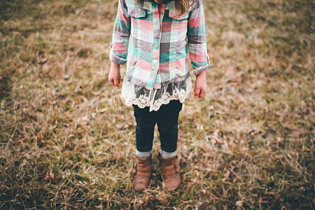 girl standing on dried leaved field thumbnail