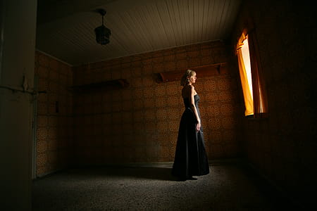 Woman Wearing Black Sleeveless Dress Standing Near Open Window thumbnail