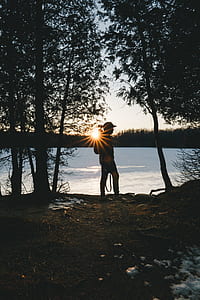 silhouette of man walking near the tree during daytime thumbnail