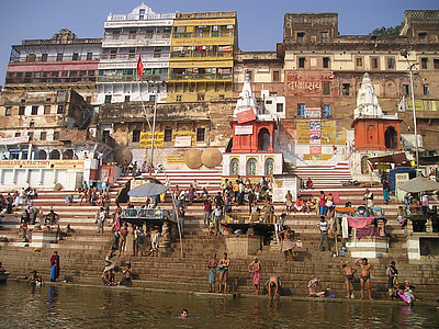 people standing and sitting on concrete stairs near body of water thumbnail