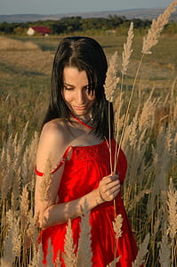 woman holding brown grass wearing red spaghetti strap top thumbnail