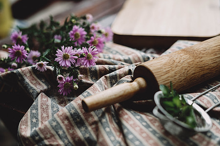 pink Asters flowers near brown wooden rolling pin thumbnail
