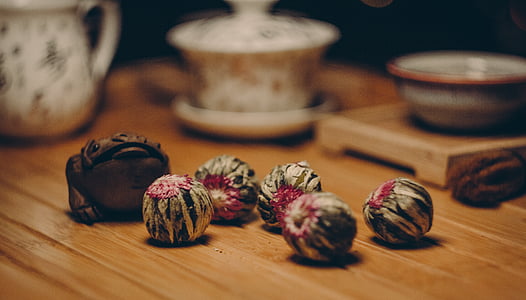 white and frog figurine and small white and gray fruits on table thumbnail