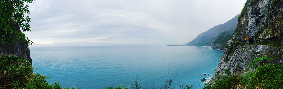 body of water near rock formation at daytime thumbnail