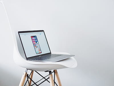 turned-on MacBook Air with space gray iPhone X display on chair thumbnail